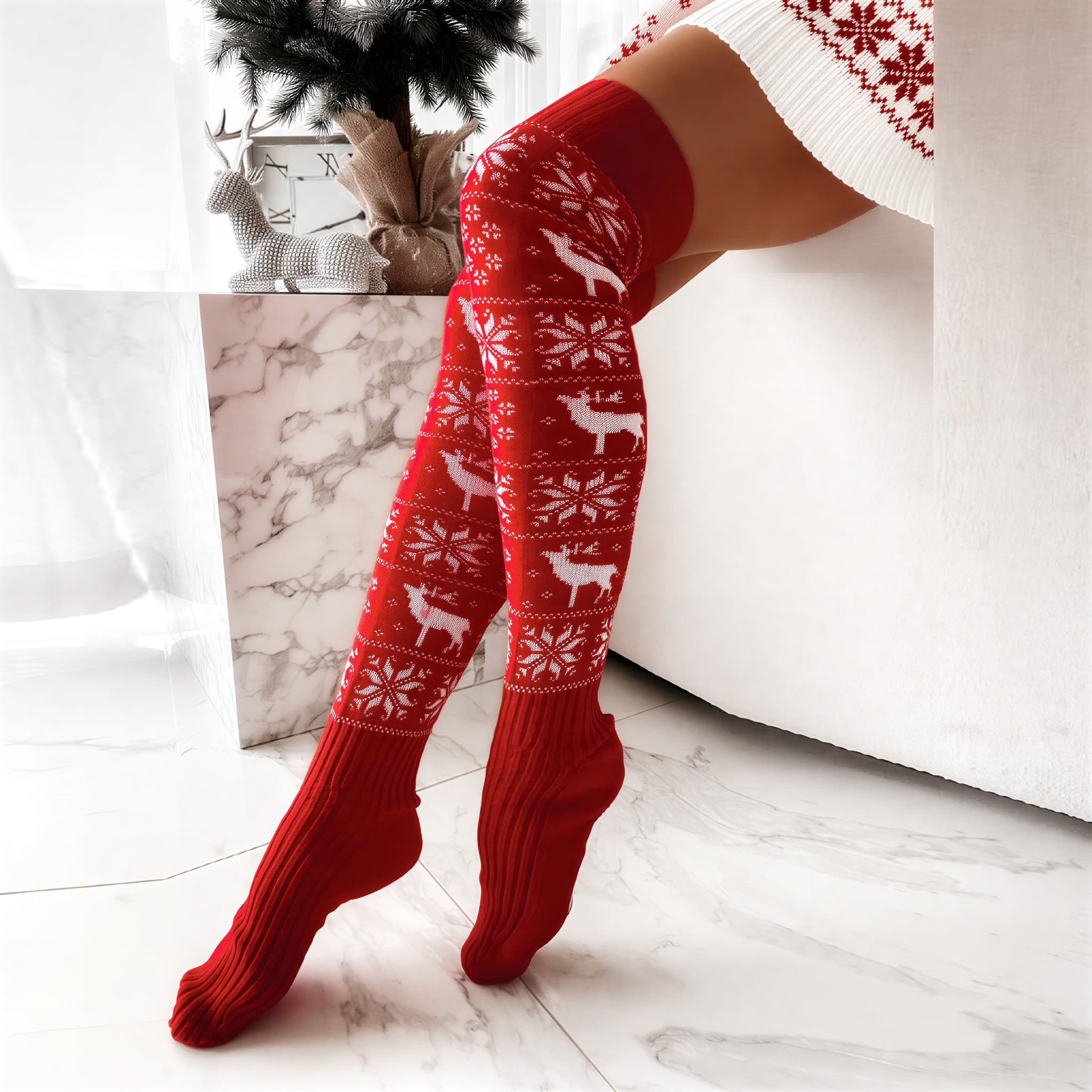 Red knee-high socks with white reindeer and snowflake pattern.